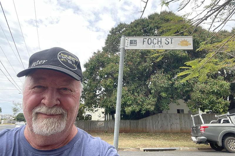 Community member standing beside a Foch Street sign named after French military commander Marshal Ferdinand Foch.