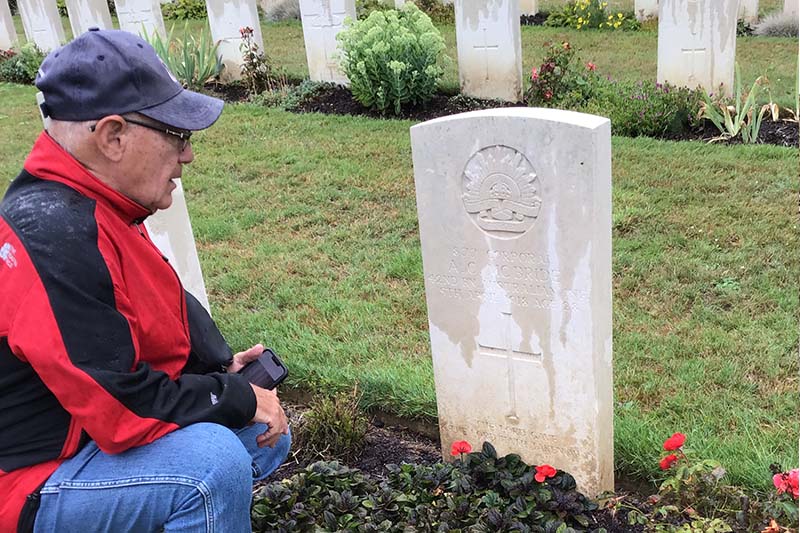Sitting at a war grave with red poppies 